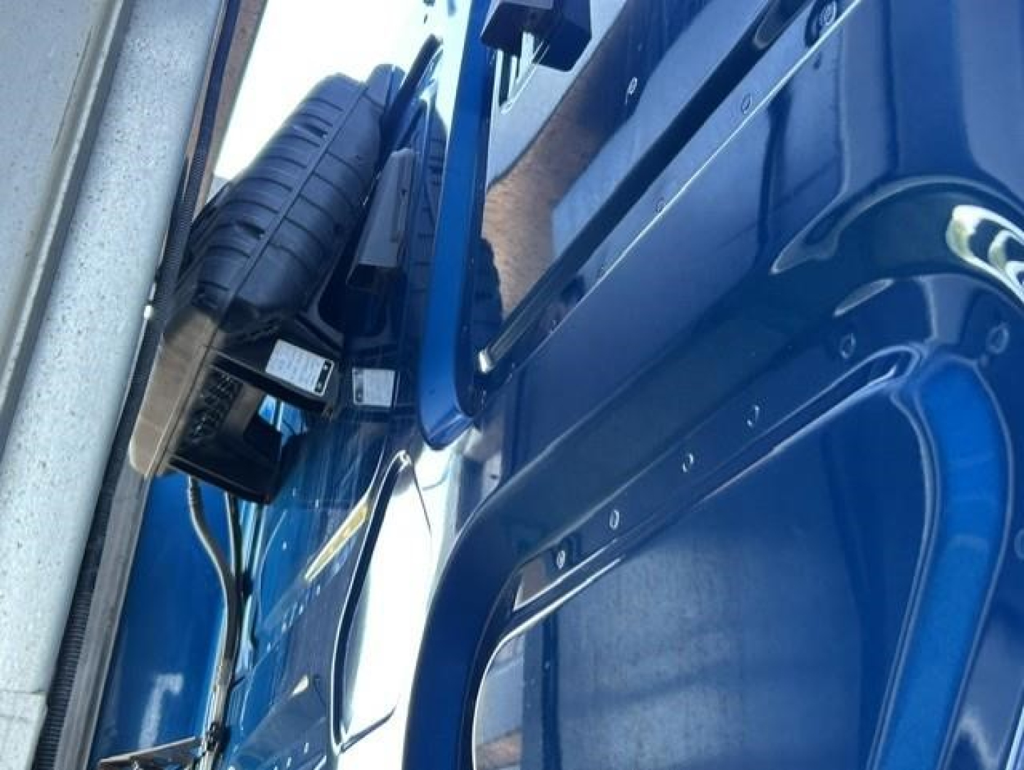 Truck cab interior side showing a spare tire and blue door panel from a 2022 Freightliner Cascadia.
