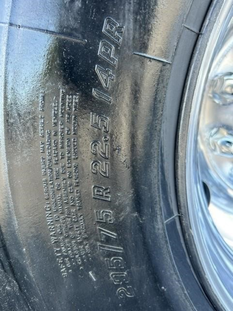 Tire sidewall showing vehicle spec markings: 275/75R22.5 14PR and other small etched text on the tire. Chrome wheel partially visible.