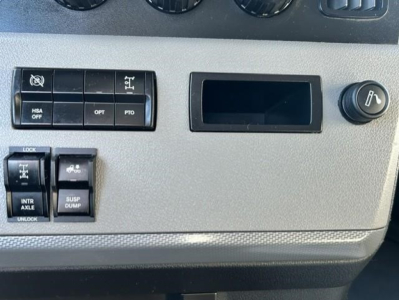 Cab interior panel of a 2022 Freightliner Cascadia showing switch cluster with HSA OFF, OPT, PTO labels, plus rocker switches and a circular air gauge knob.