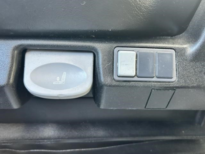 Truck interior component showing a round knob and three rectangular switches.