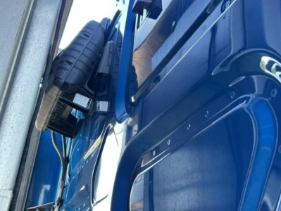 Truck cab interior side showing a spare tire and blue door panel from a 2022 Freightliner Cascadia.