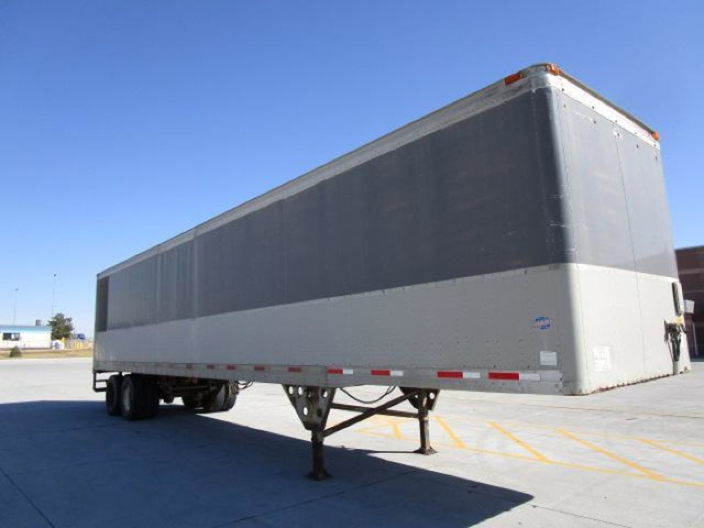 Utility van trailer shown in side-angled view with elevated front hitch and landing gear.