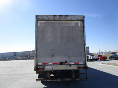 Utility van rear view showing closed trailer door with taillights and bumper.