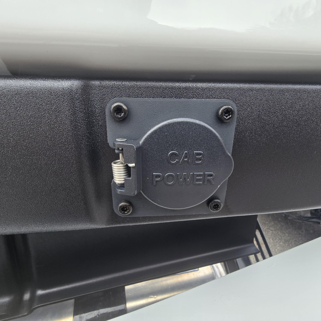 Round power inlet cover labeled 'GAB POWER' on a truck bumper, with a spring latch and four screws.