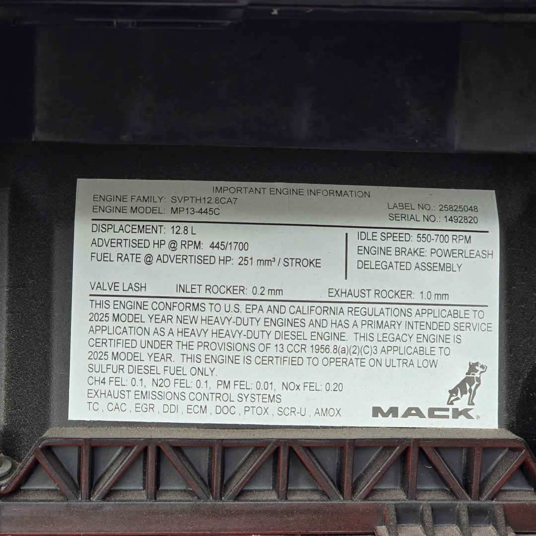 Engine information placard on Mack MP13 engine showing specifications and labels inside a truck engine bay.