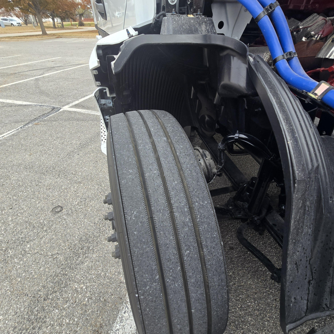 Mack PR64T76M truck front dual axle with large tire and blue hoses visible