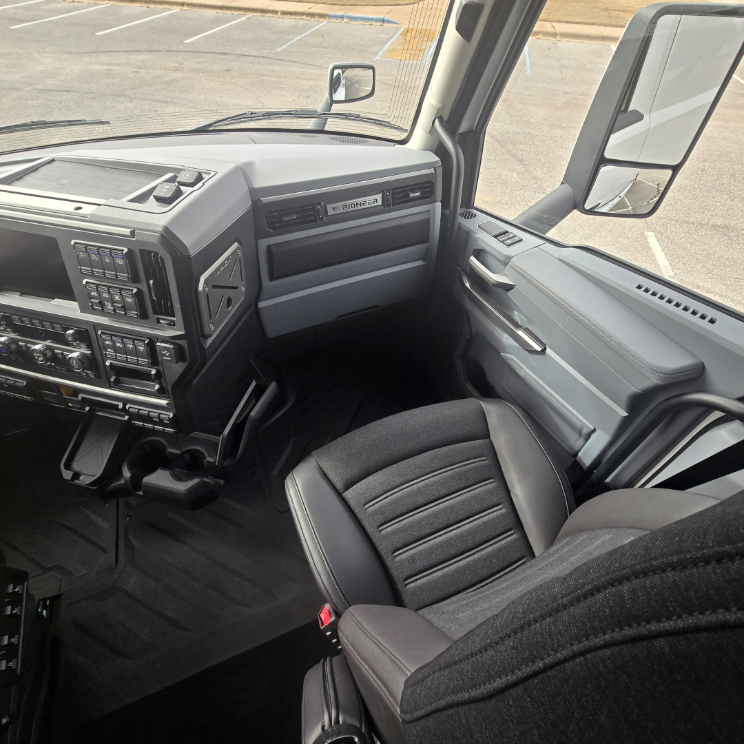 Cab interior of a 2026 Mack PR64T76M truck showing dashboard, steering column, and front passenger seat with grey and black trim.