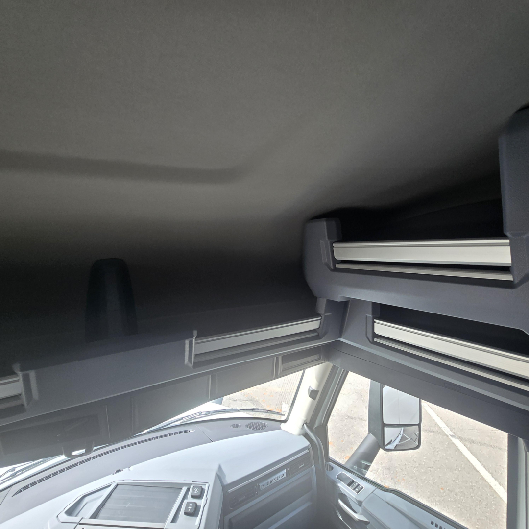 Cab interior of a 2026 Mack PR64T76M sleeper truck showing overhead bunk area and dashboard edge.