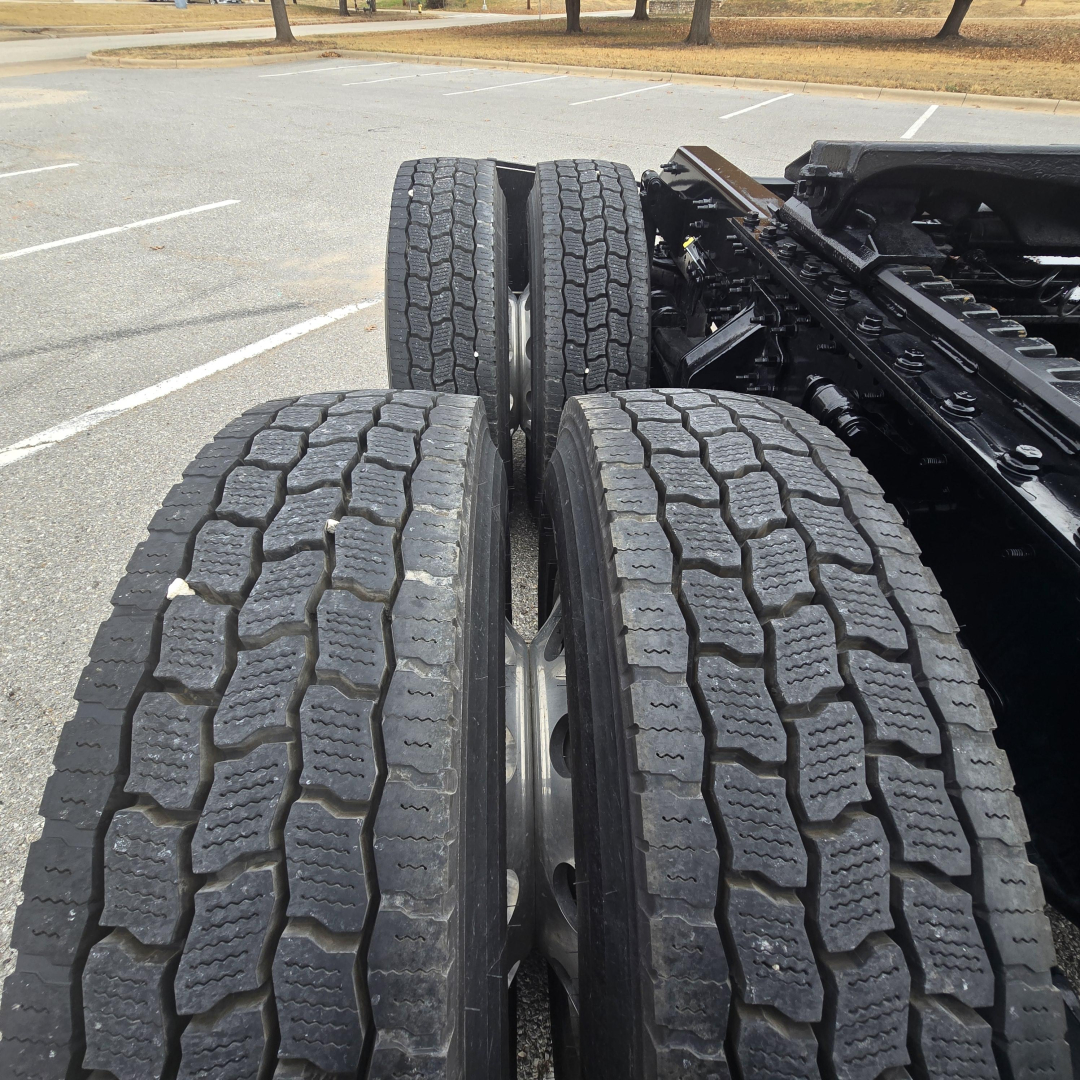 Dual rear truck tires on a Mack PR64T76M chassis showing tread pattern and driveline area.