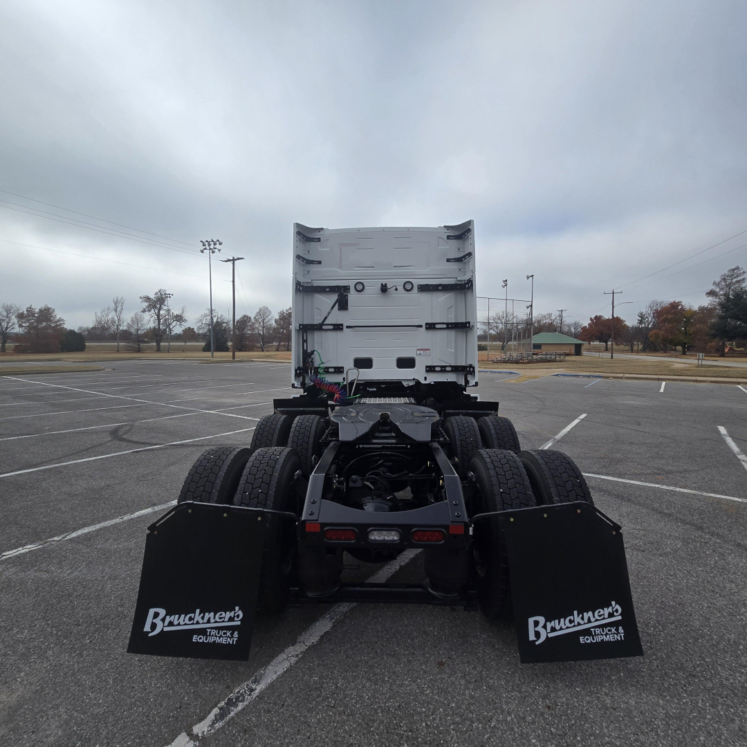 Rear view of a new Mack PR64T76M truck tractor showing dual rear axles, mud flaps with Bruckners logo, and fifth wheel hitch area.