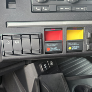 Mack PR64T76M truck dashboard switches with red trailer air supply and yellow parking brake buttons visible.