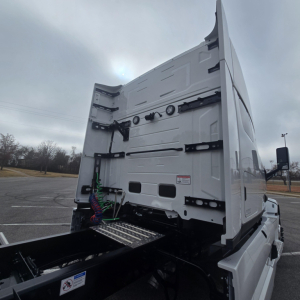 Mack PR64T76M conventional sleeper truck rear view showing fifth wheel area, rear doors, and hydraulic components.