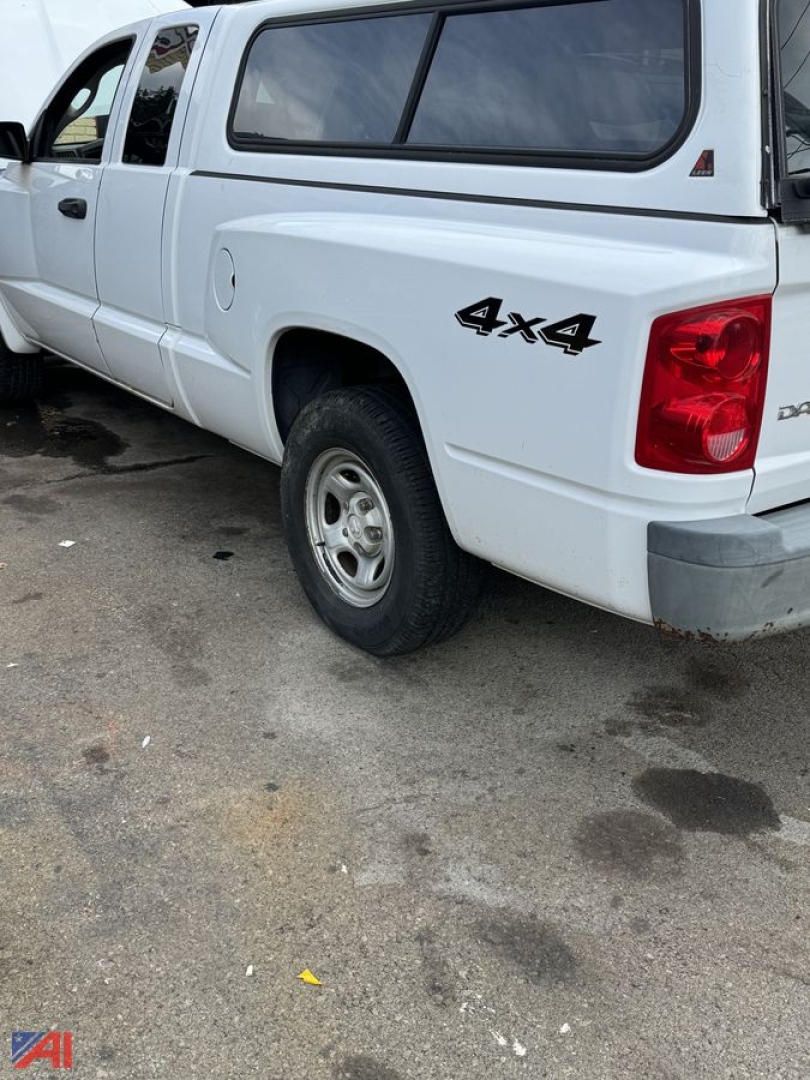 Dodge Dakota pickup truck with cap and 4x4 decal on rear quarter panel.