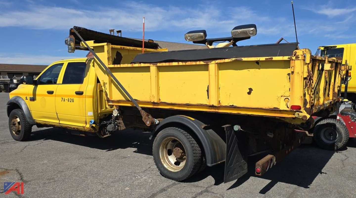 Dump truck body and plow mounted on a 2011 Dodge Ram 5500 chassis cab in yellow, side view showing dump bed, plow frame, and dual rear wheels.