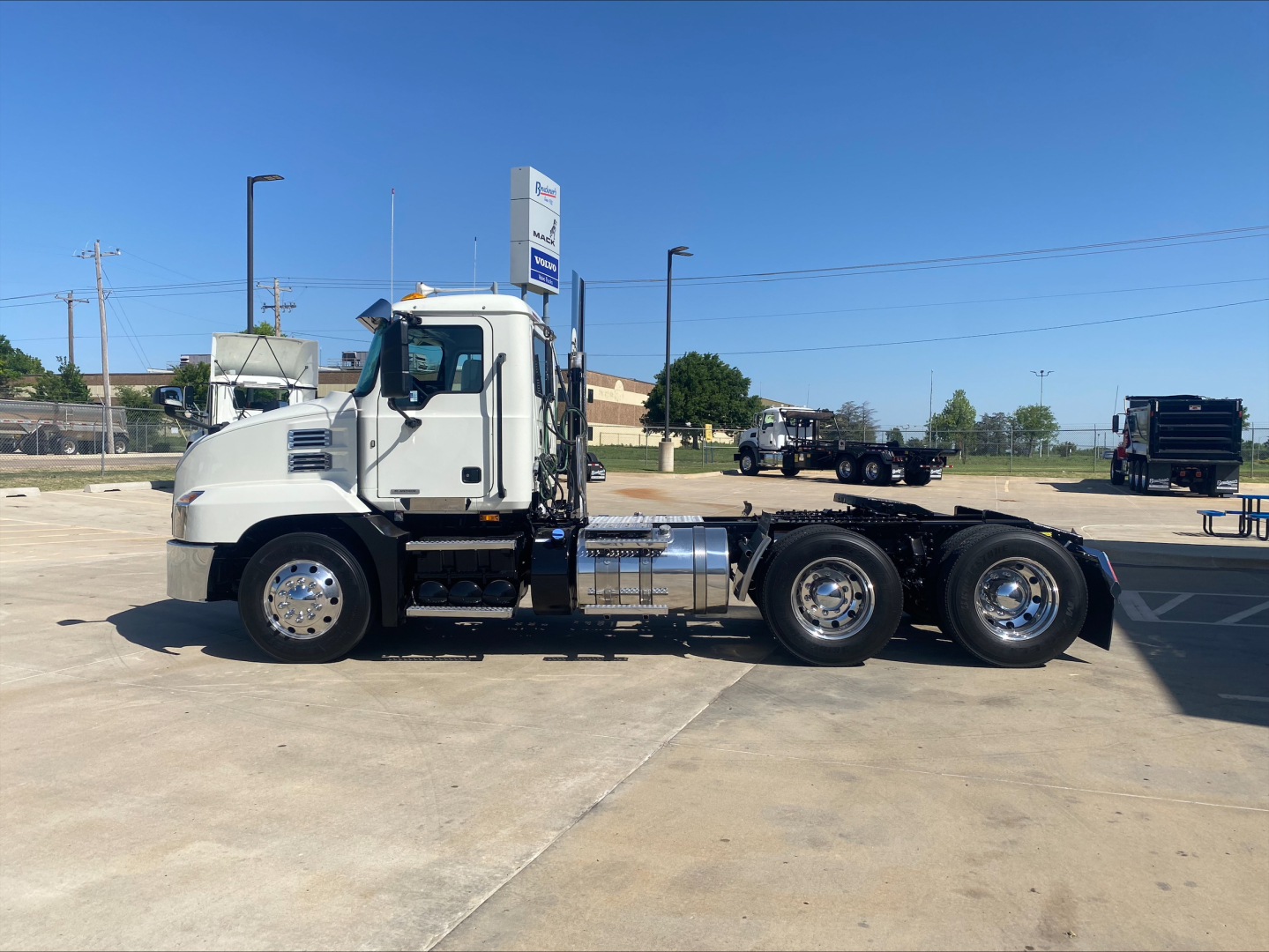 Truck chassis side view showing 2021 Mack AN64T conventional daycab with dual rear axles and chrome fuel tanks.