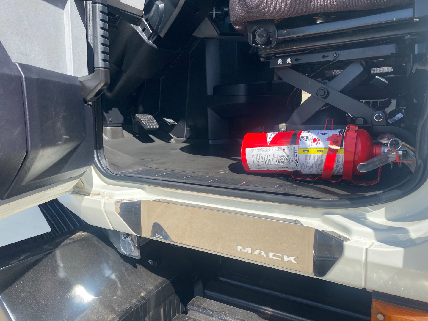 Mack AN64T cab interior entry with floor, fire extinguisher, and Mack branding on door sill.