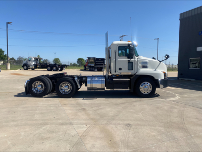 Truck: 2021 Mack AN64T conventional daycab side view showing cab, dual rear axles, chrome fuel tanks, and aluminum wheels.