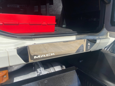 Mack AN64T cab interior showing entry step with Mack logo plate and storage bin