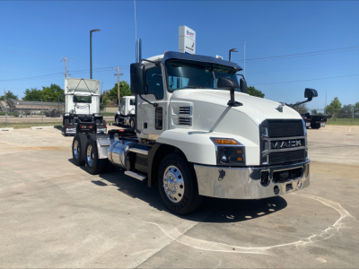 Prime white 2021 Mack AN64T conventional daycab truck side-front view showing dual rear axles, large grille, chrome bumper, and Mack badge.