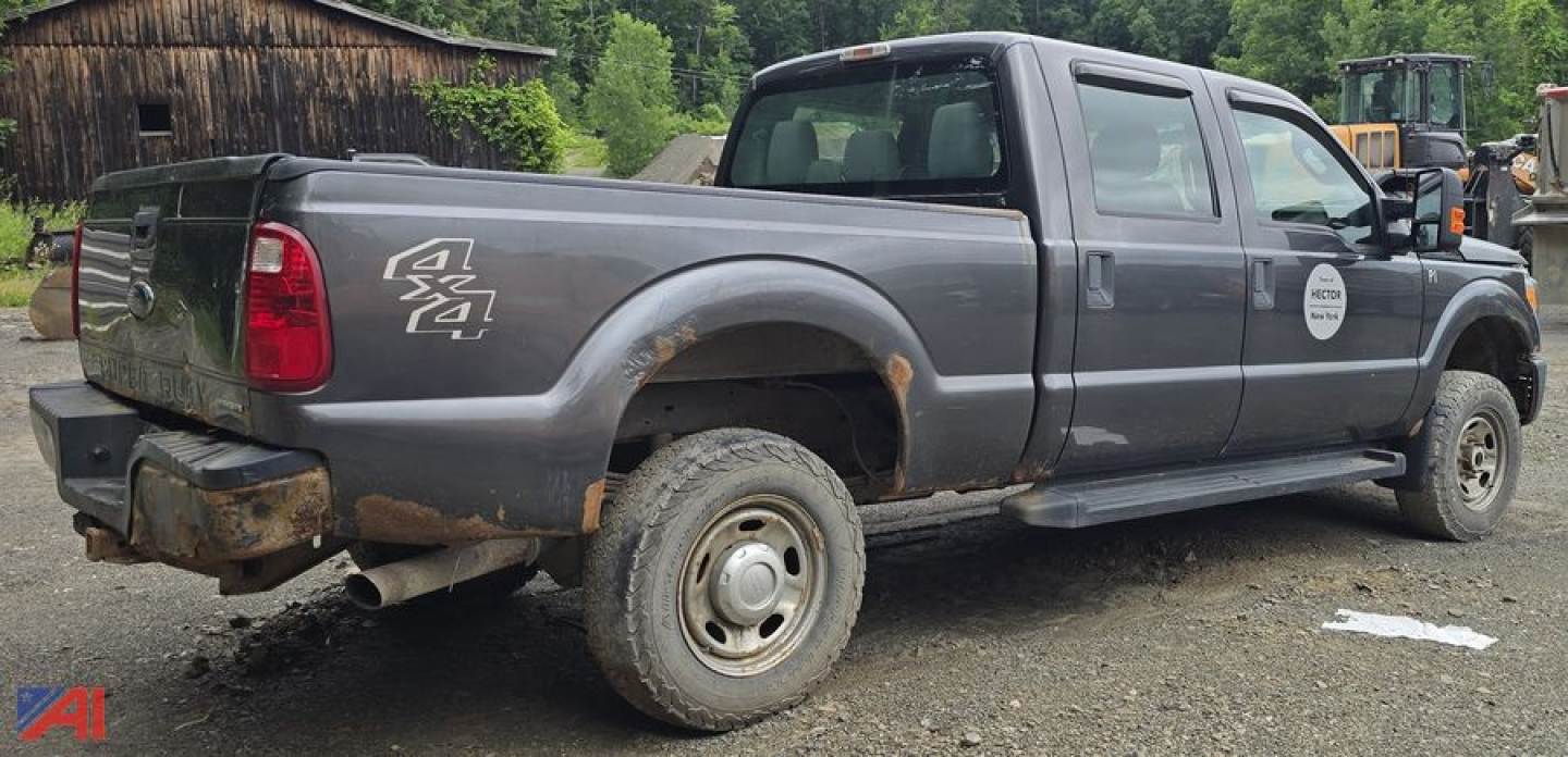 Ford F-250 Super Duty pickup with plow, 4x4 badge, extended cab, gray, rear hitch, dirt and mud on tires.