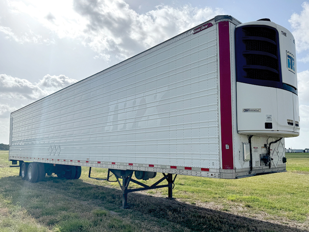Great Dane Everest SS reefer trailer with curved refrigeration unit at front, white corrugated sides, purple vertical accents, raised landing legs, set on a grassy field.