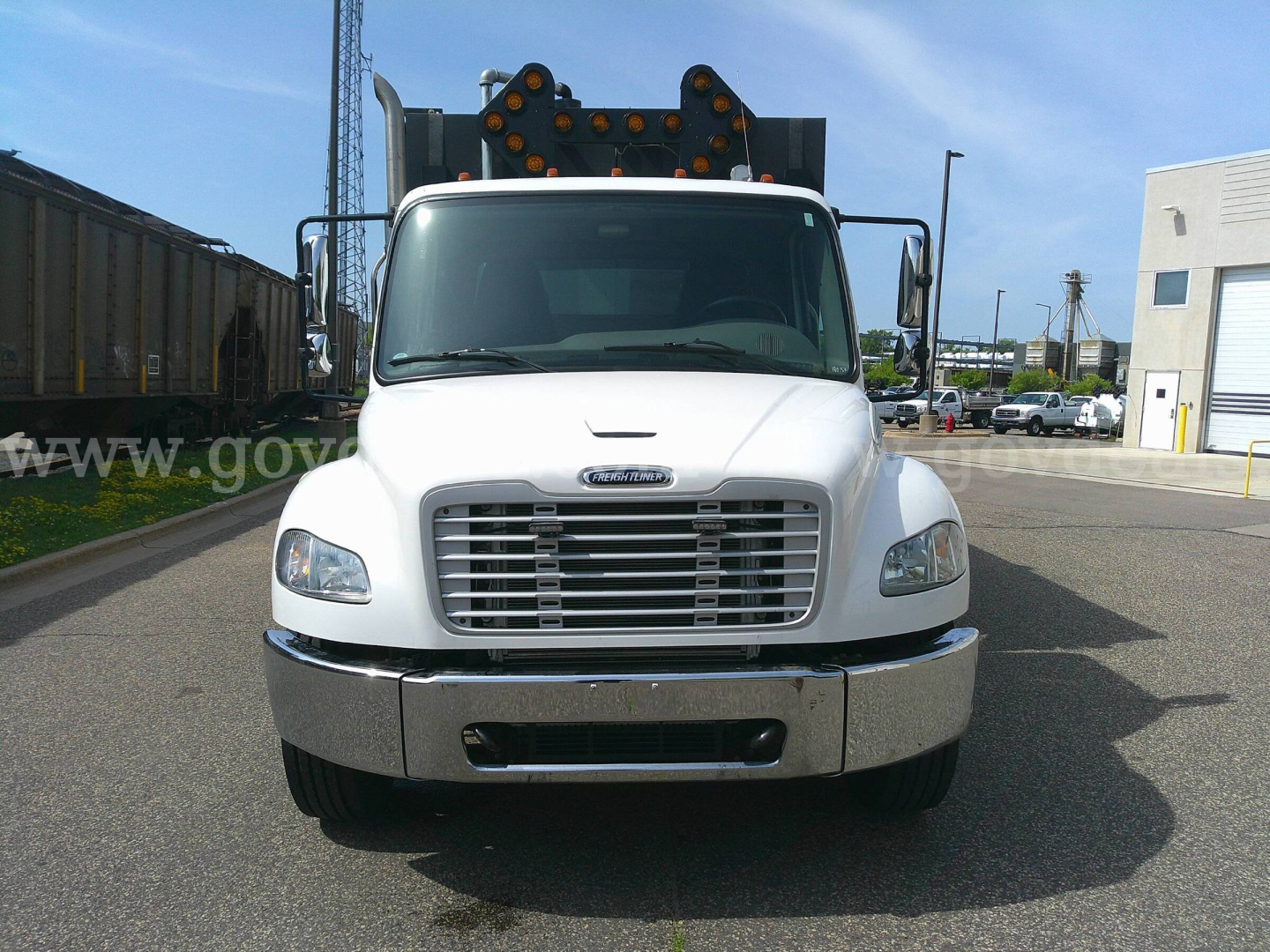 Front view of a white 2018 Freightliner M2-106 service truck showing grille, bumper, and dual mirrors.