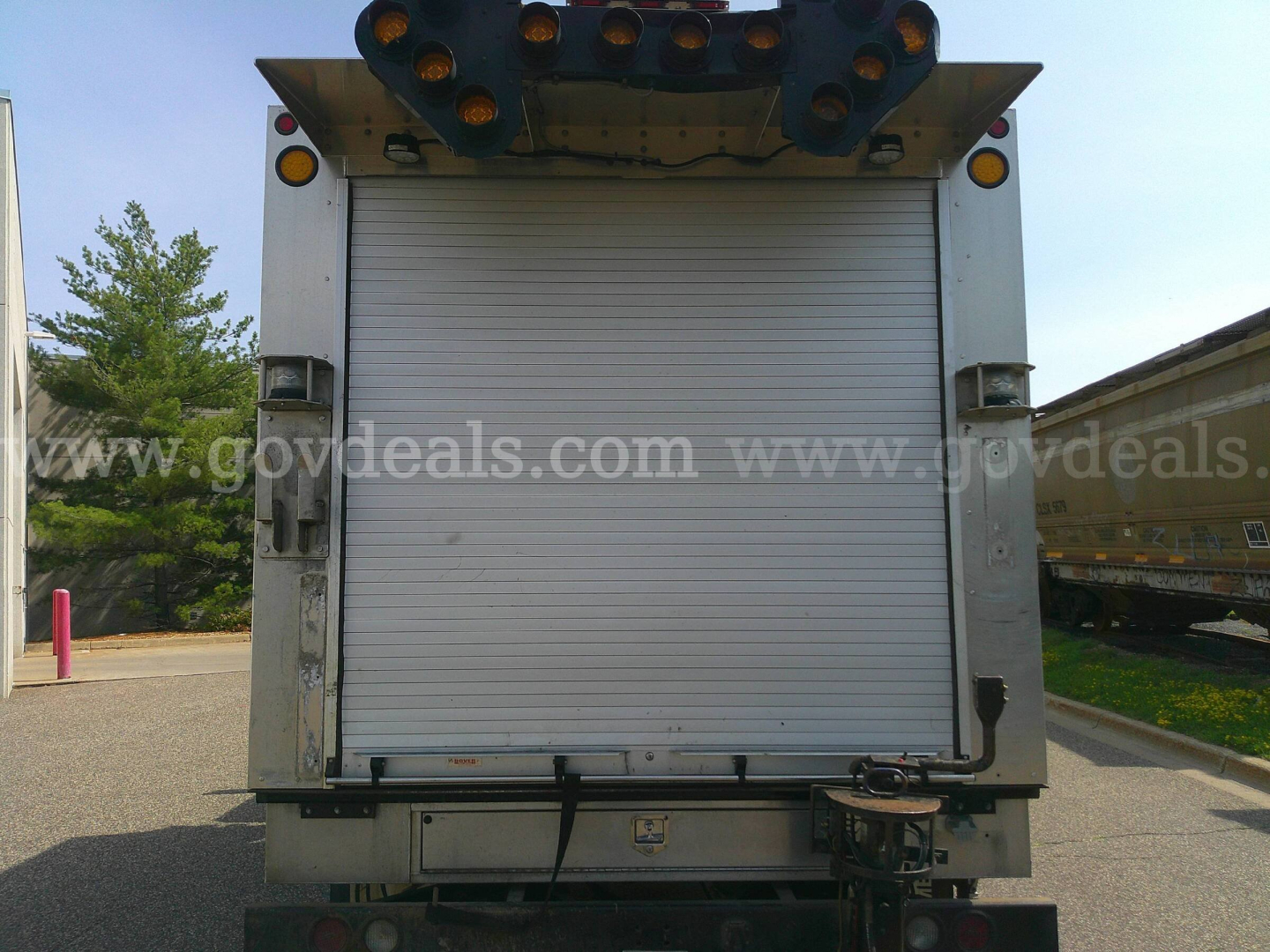 Rear view of 2018 Freightliner M2-106 service/utility truck with roll-up tailgate and equipment rack visible.