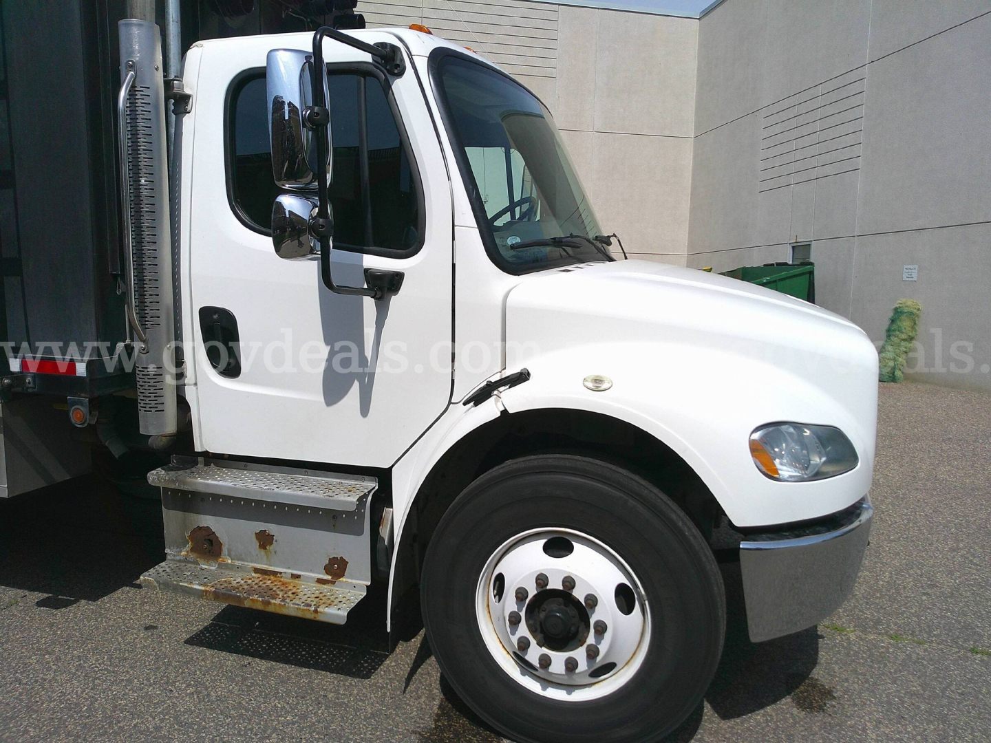 Service/Utility truck: 2018 Freightliner M2-106 side view showing front fender, wheel, cab, and fuel or step area with rust on lower step.
