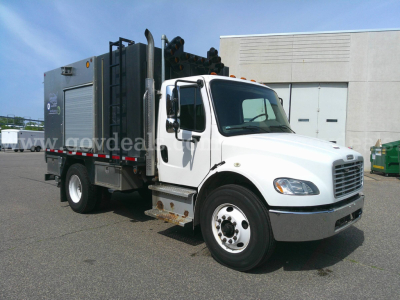 Truck cab with side view showing Freightliner M2-106 service utility body, white cab, chrome bumper, rear utility equipment; visible text includes side graphics and equipment labels.