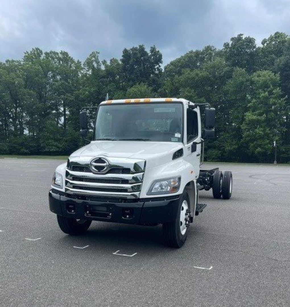 Hino L7 cab chassis truck front-left view with white cab and dual rear wheels, stock number H27004, new vehicle in lot.