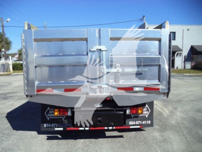 Isuzu NPR-HD dump bed rear view showing tailgate and bumper with reflective red/white strips.