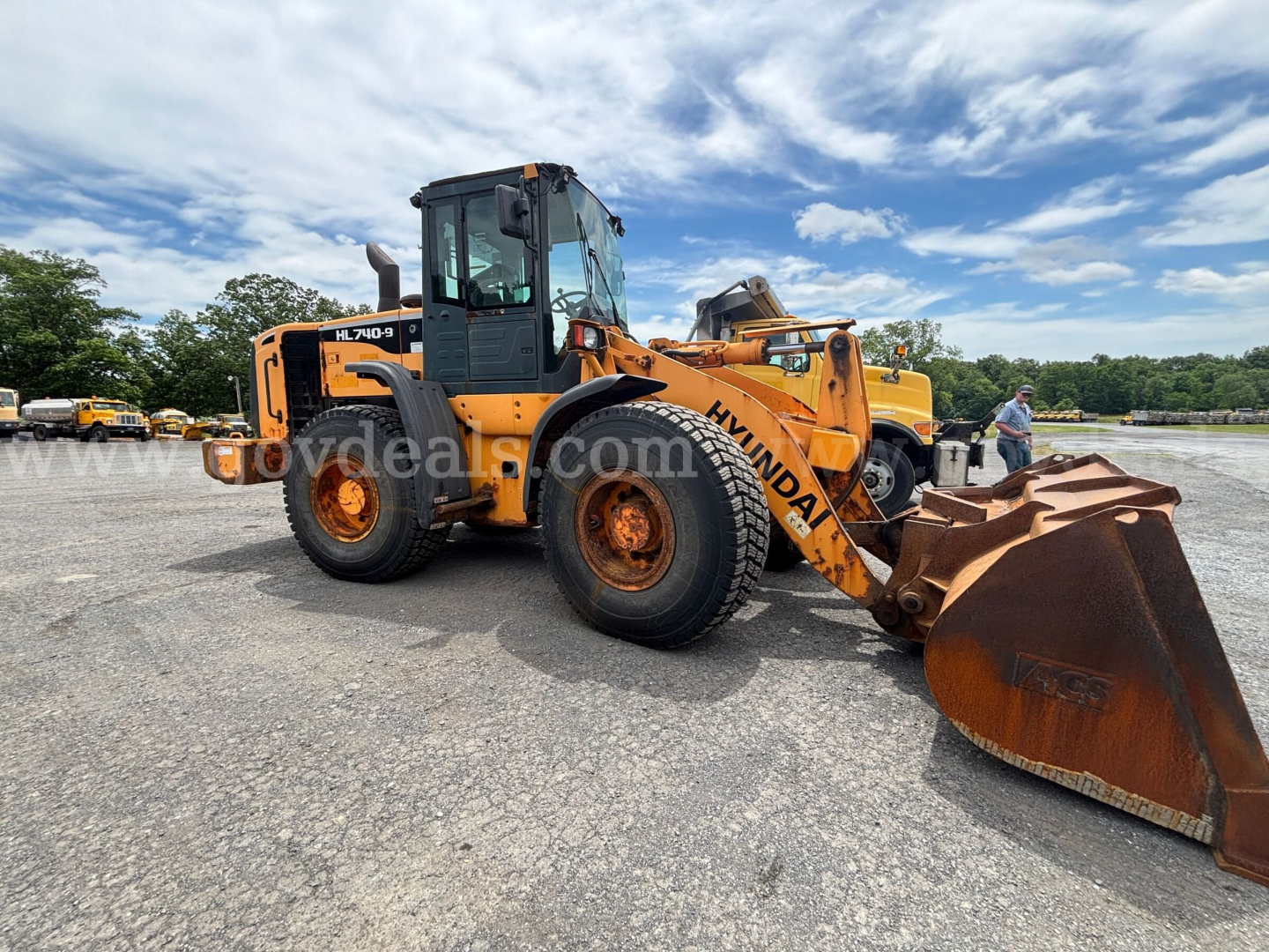 Hyundai HL740-9 wheel loader in an open lot, side view with large rust-colored bucket; visible text on machine includes HL740-9 on cab area and Hyundai marking on arm; no detailed labels readable.