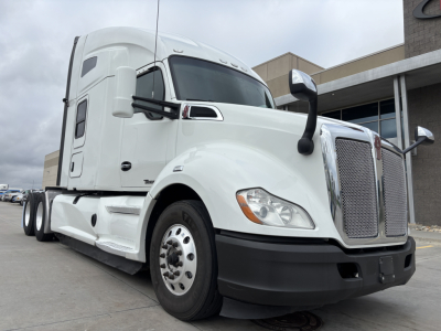 Kenworth T680 tractor unit in white, front-right view showing grille, bumper, and side mirror with sleeper cab.