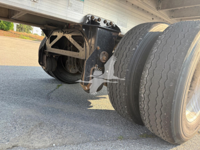 Trailer axle and suspension undercarriage with dual rear tires; part of a 2020 Reitnouer Maxmiser flatbed trailer, showing wheel assembly and frame components.