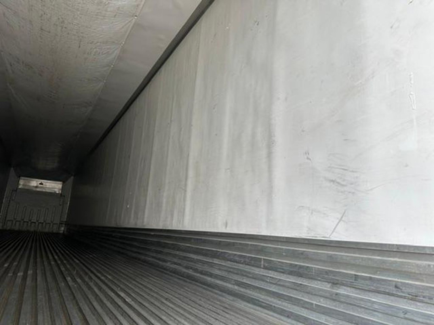 Trailer interior cargo area showing ribbed floor and rear door, 2016 utility reefer in-service.
