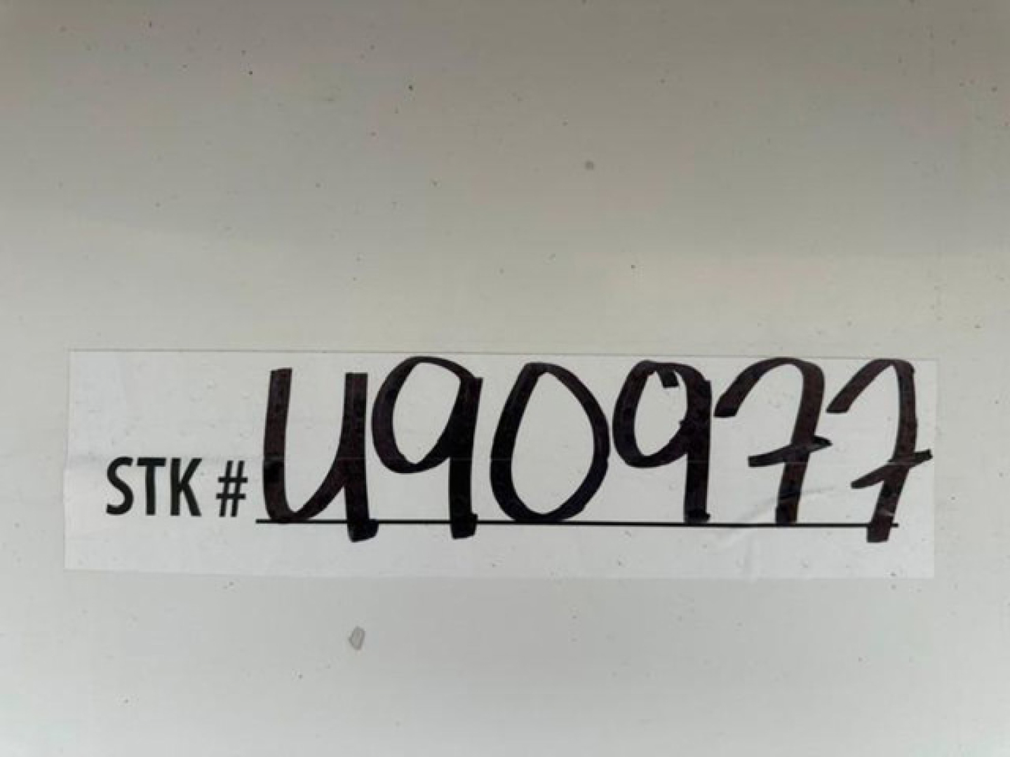 Sticker with STK # U40977 handwritten in black on white label.