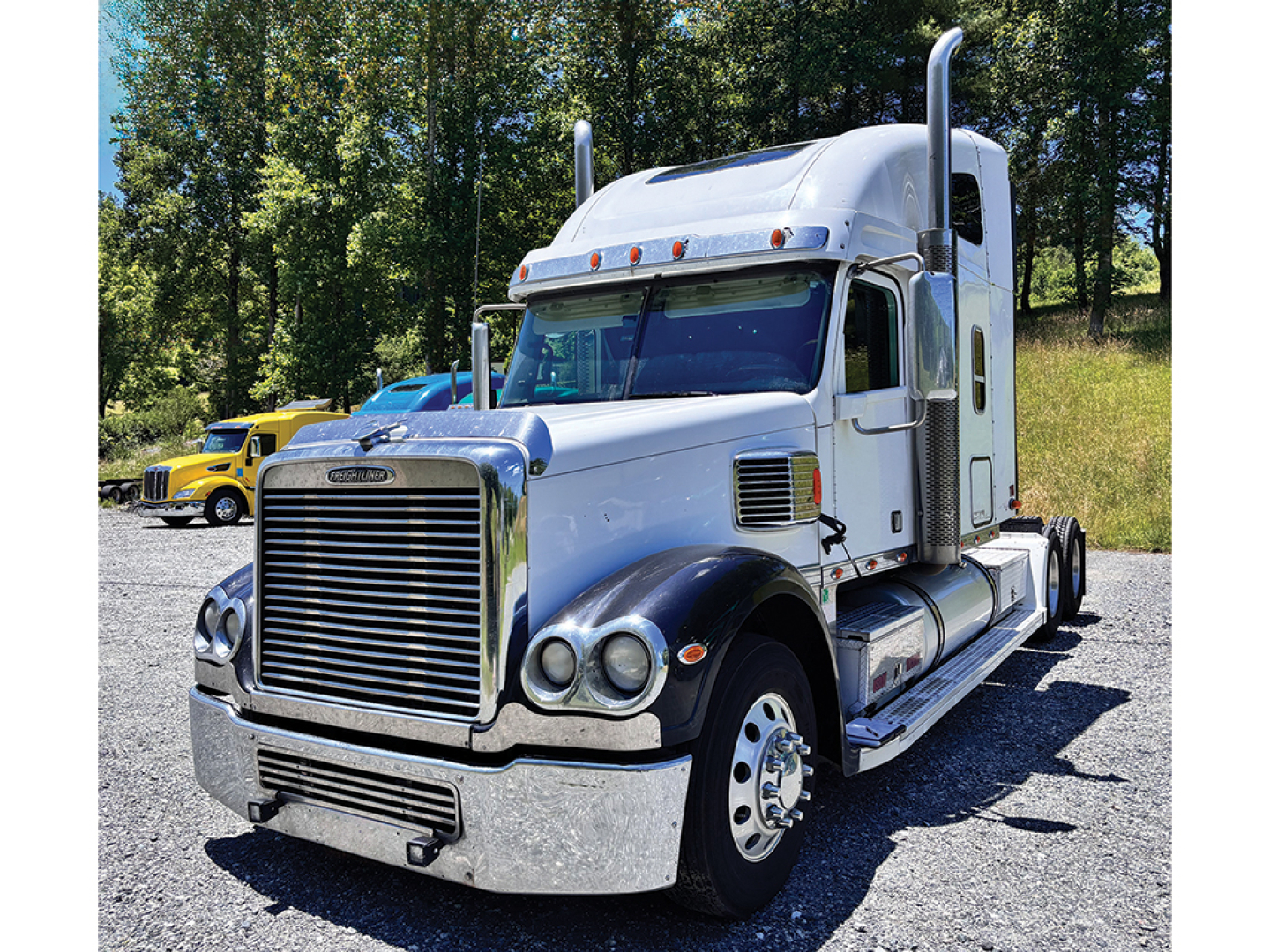 Freightliner Coronado truck shown in daylight with chrome grille, large bumper, dual exhaust stacks, and sleeper cab.