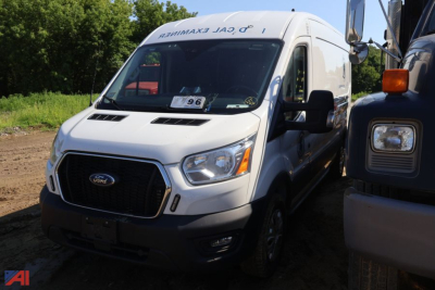 Ford Transit 350 van in a salvage lot, front-left view, white cargo van with black grille and prominent Ford emblem.
