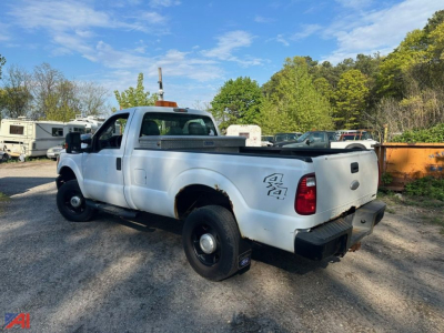 Ford F-250 Super Duty pickup truck 4x4, white extended cab with utility bed and dual rear wheels, visible rear quarter, tailgate, and 4x4 badge.