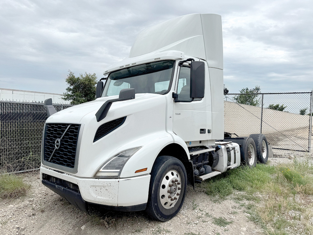 Volvo VNR truck cab and front wheel view with sleeper cabin in white, side profile, 6x4 tractor setup, highway tires visible.