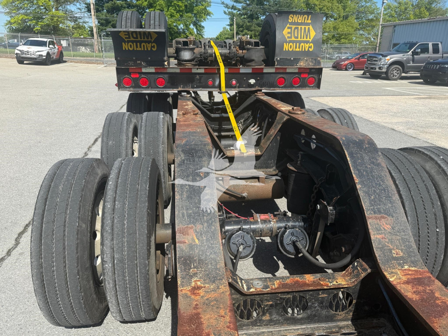 Trailer chassis showing suspensions and axles with dual rear wheels on a lowboy trailer.