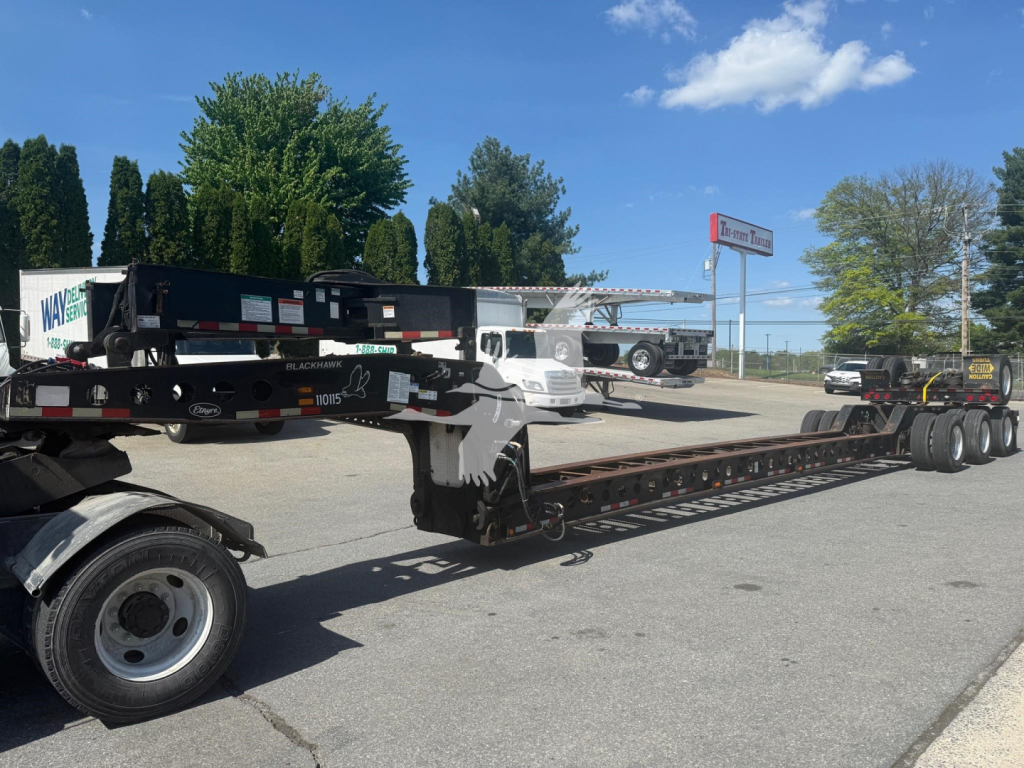 Etnyre Lowboy trailer attached to a long flatbed with multiple axles visible, used condition, VIN tag not readable from distance.