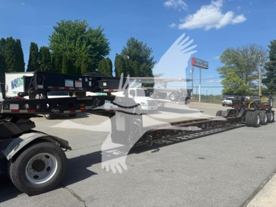 2014 Etnyre Beam lowboy trailer in a dealer lot, long flatbed with multiple axles, side rails, and tires visible.