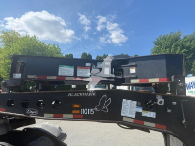 Etneyre Blackhawk lowboy trailer rear view showing warning labels and model markings; white bird/hand graphic and serial numbers on frame