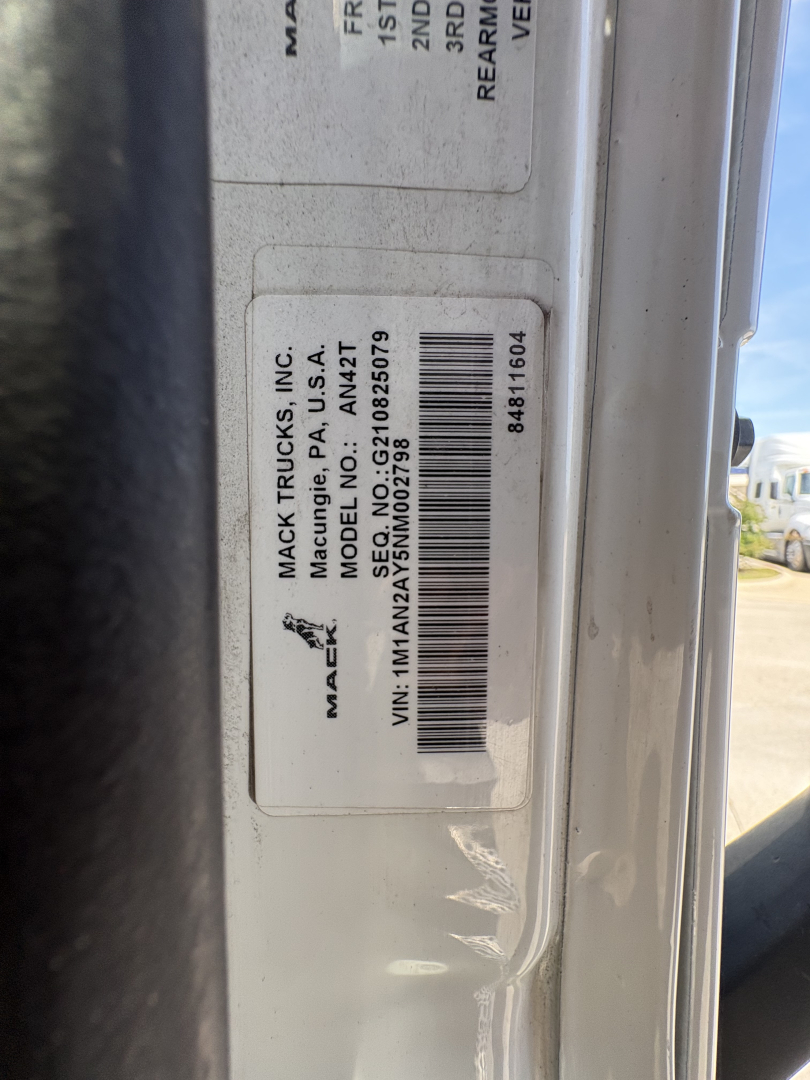 Label on Mack truck door jamb with VIN sticker and barcode showing Mack Trucks Inc information and VIN 1M1AN2AY5NM002798.