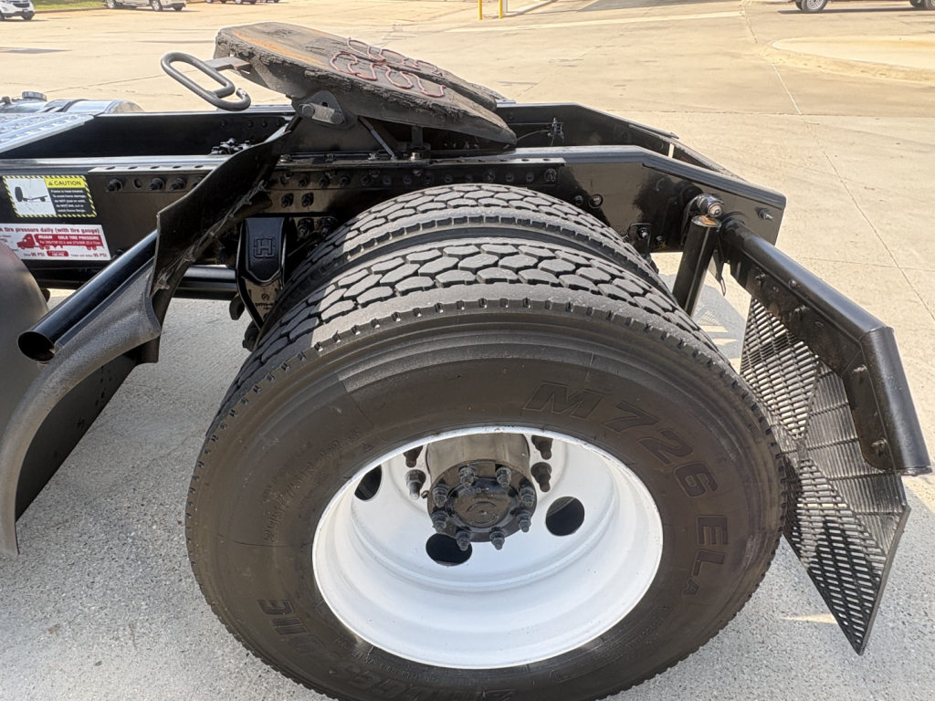 Mack AN42T truck rear wheel area showing single tire mounted on white steel rim, fender, and frame steps.