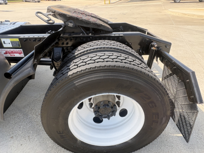 Mack AN42T truck rear wheel area showing single tire mounted on white steel rim, fender, and frame steps.