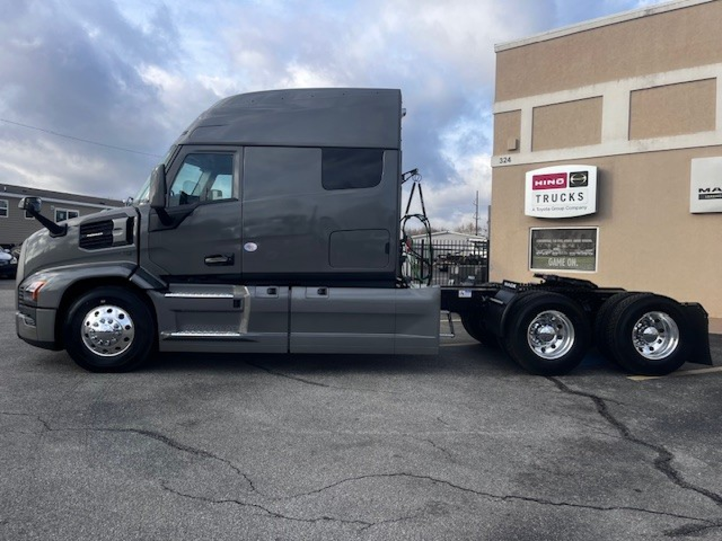 Mack PR64T76M truck tractor side view showing long air-cleaner, tall sleeper cab, tandem rear axles, and chrome fuel tanks.
