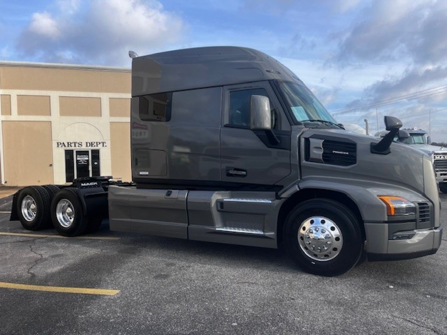 Mack PR64T76M truck tractor side view showing black exterior and chrome wheels with sleeper cab