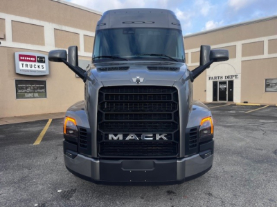 Front view of a Mack PR64T76M truck showing large black grille with 'MACK' lettering, headlights on each side, mirrors, and a high sleeper cab.